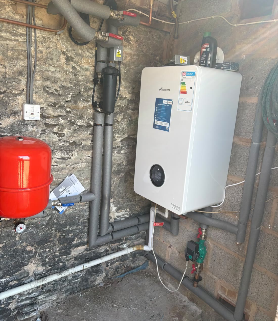 A new 40kW Worcester Bosch boiler and system filter fitted on a stone wall